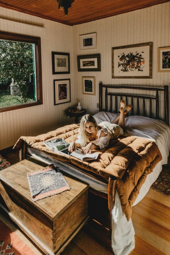 Young woman reading and journaling in bed